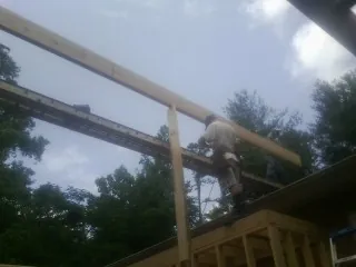 Carpenter setting a ridge beam over a new addition frame — Ice Dam Removal by Roofing Brothers in Midland Park