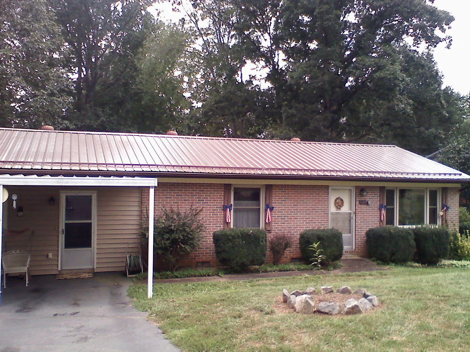 Bronze metal roof and carport on a brick ranch home — Roof Repair work by our crew in Midland Park